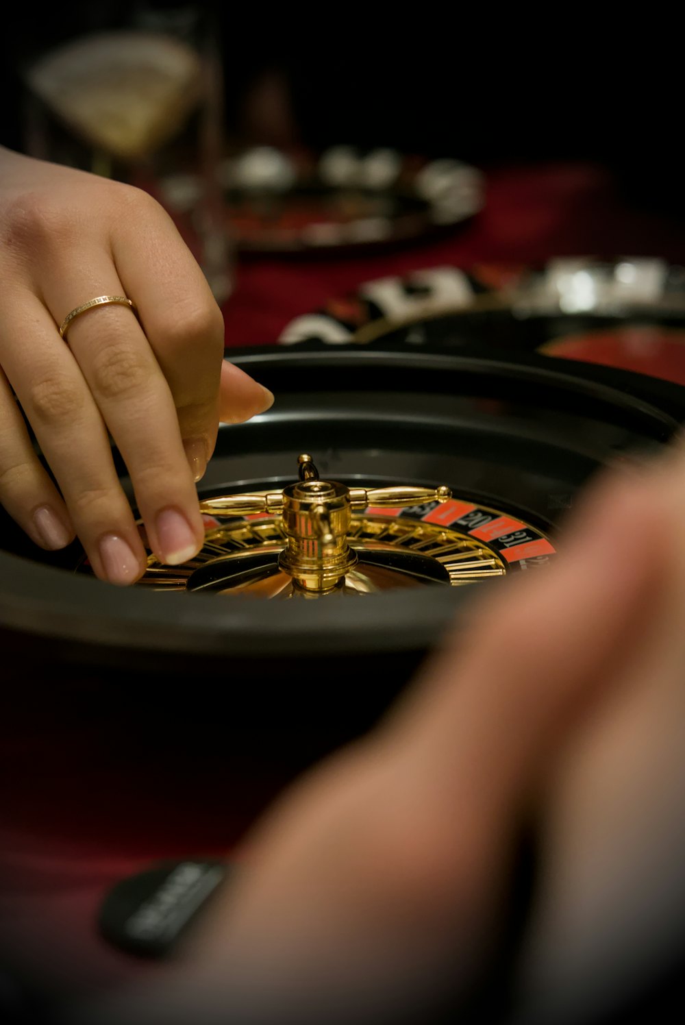Tangan pemain meletakkan chip di atas meja roulette, mewakili kategori live casino