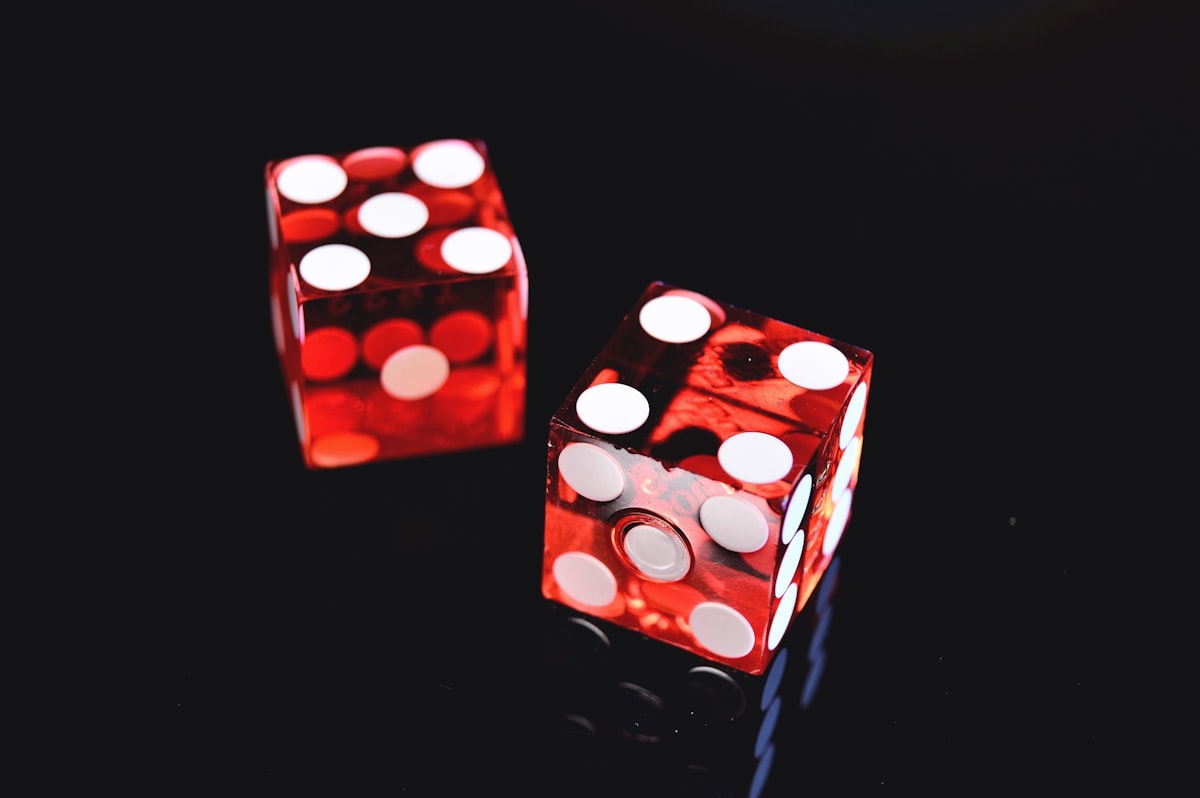 Dua dadu merah putih di atas meja, melambangkan rangkuman promosi dan bonus